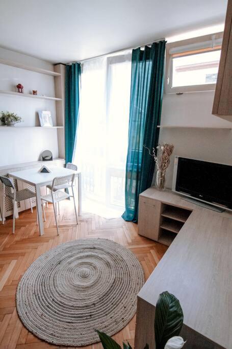 a living room with a table and a large window at Przytulne mieszkanie w centrum in Warsaw