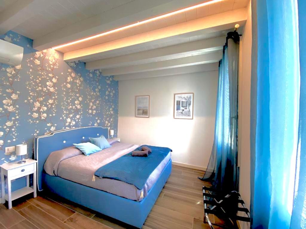 una camera con un letto blu e una parete blu di Star Soave Rooms - Locazione Turistica a Soave