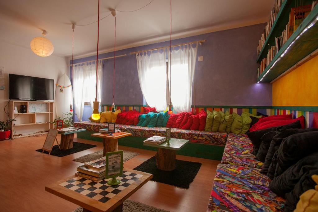 a living room with a colorful couch and tables at Ericeira Surf Camp in Ericeira