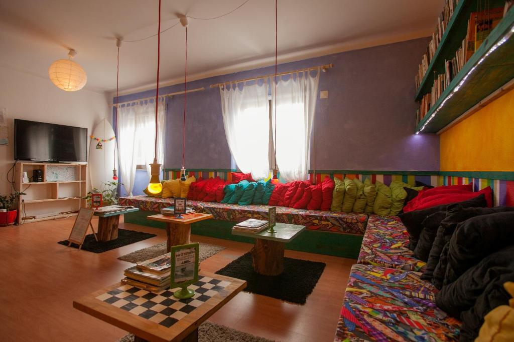 a living room with a colorful couch and tables at Ericeira Surf Camp in Ericeira