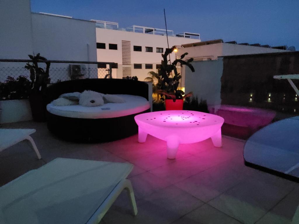 a patio with a dog bed and a pink light at Villa Marjal in Guardamar del Segura