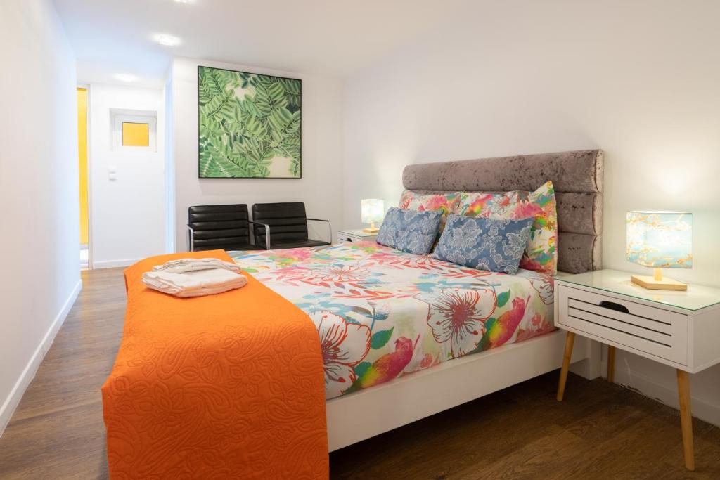 ポルトにあるApartamento Qian porto Centroのベッドルーム1室(オレンジ色の毛布付きのベッド1台付)
