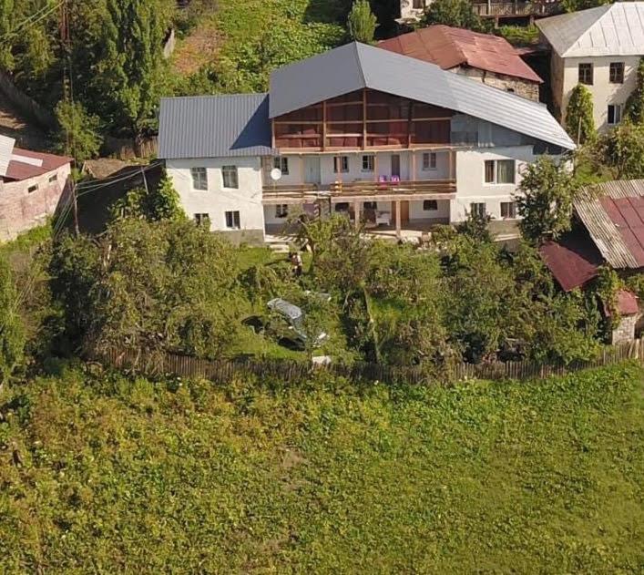 a large house in the middle of a field at Guest House IRAKLI in P'ari