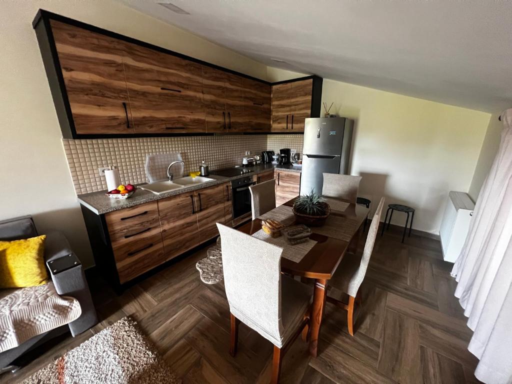 Il comprend une cuisine équipée d'une table et de chaises. dans l'établissement Lovely and cozy 1-bedroom house with a sunny patio, à Korçë