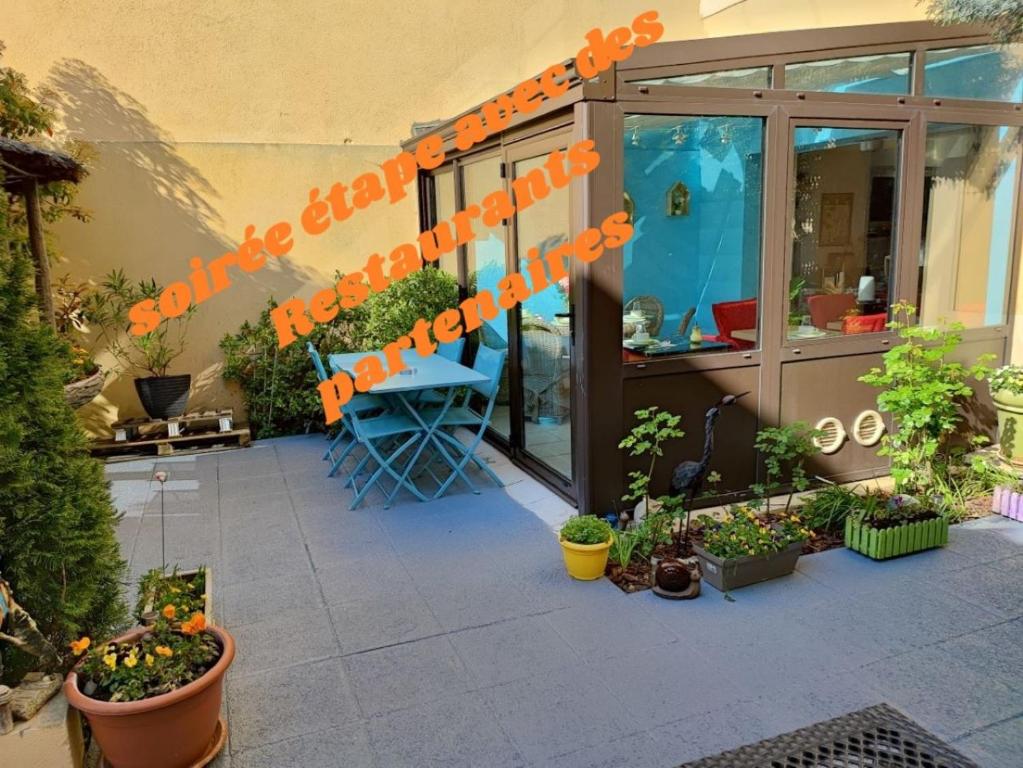 a patio with plants and orangebons on the side of a building at Hôtel du Fort in Meulan