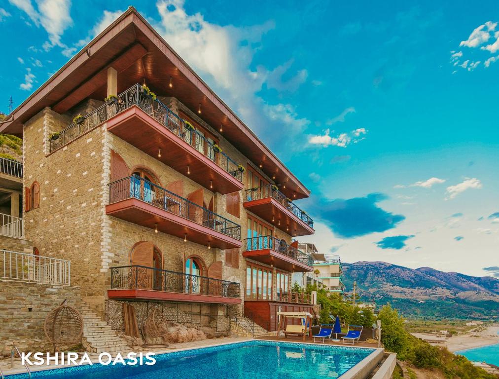 a hotel with a swimming pool in front of a building at Kshira Oasis - Luxury 7-Bedroom Vila in Qeparo