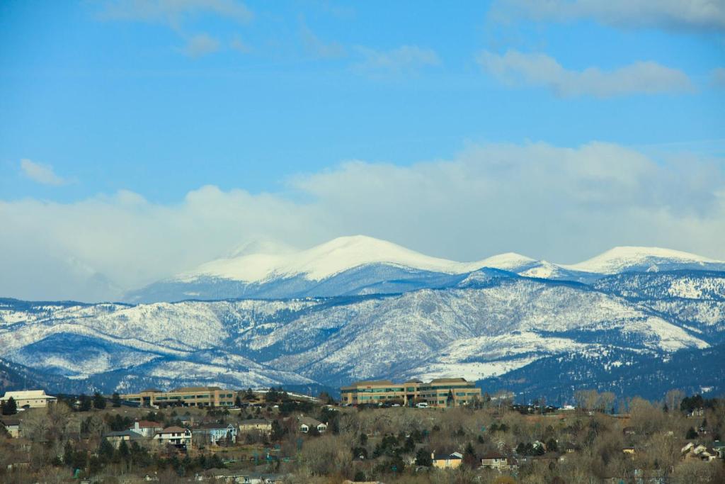 a snowy mountain range with houses and buildings and snow covered mountains at Renaissance Boulder Flatiron Hotel in Broomfield
