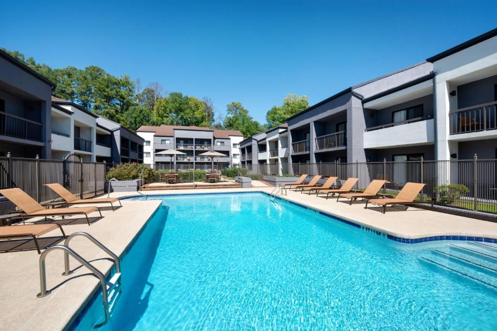 una piscina con tumbonas en un complejo de apartamentos en Courtyard by Marriott Birmingham Homewood, en Birmingham