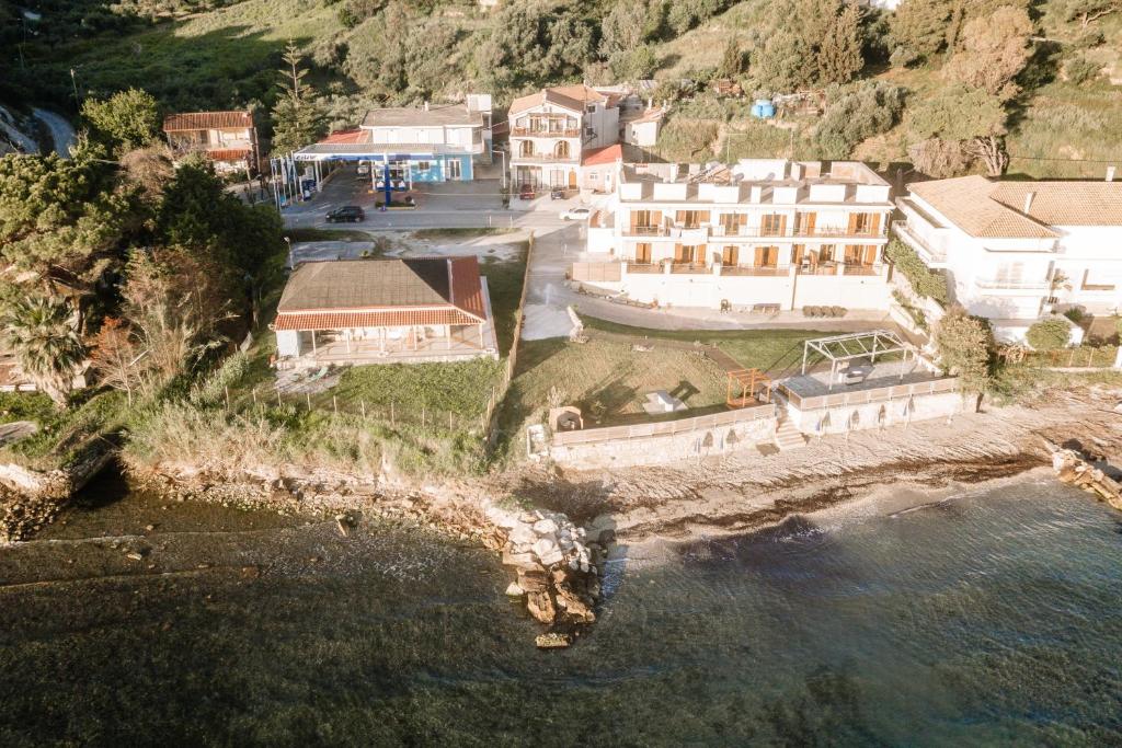 Casa di Cuore - Beachfront في أرغاسي: اطلالة جوية على منزل على تل بجوار الماء