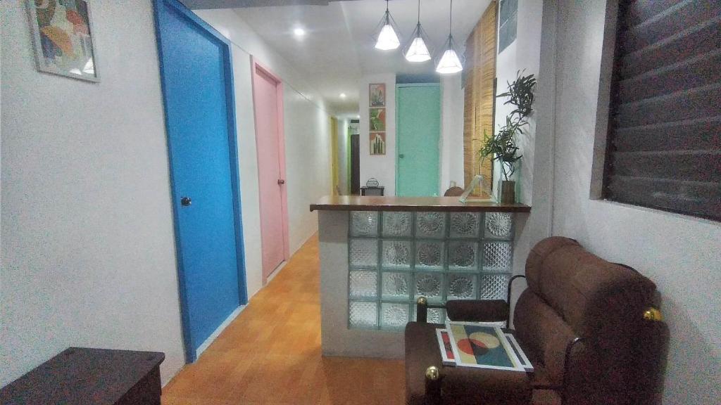 a hallway with colorful doors and a chair in a room at Mabs Hostel in El Nido