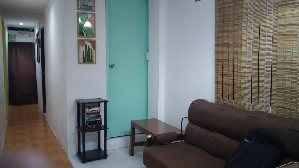 un soggiorno con un divano e un tavolo di Mabs Hostel a El Nido