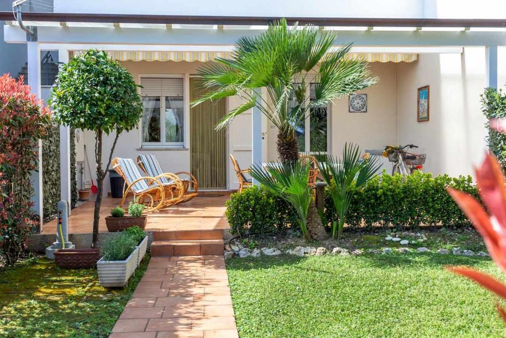 ein Haus mit einer Terrasse mit Stühlen und Bäumen in der Unterkunft R28 Trilocale con giardino a due passi dal mare in Marcelli