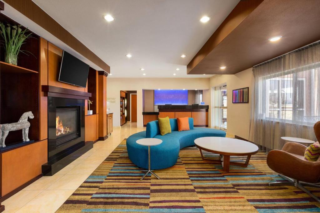 a living room with a blue couch and a fireplace at Fairfield Inn & Suites Amarillo West/Medical Center in Amarillo