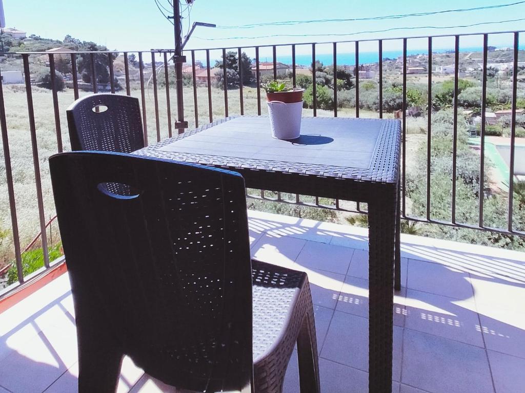a table and chairs on a balcony with the ocean at Appartamento Rosariomaria in Realmonte