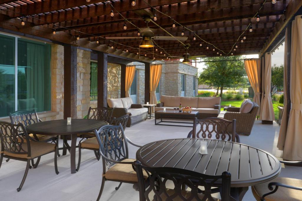 un patio con mesas y sillas y un sofá en Fairfield Inn & Suites by Marriott Dallas Plano The Colony en The Colony