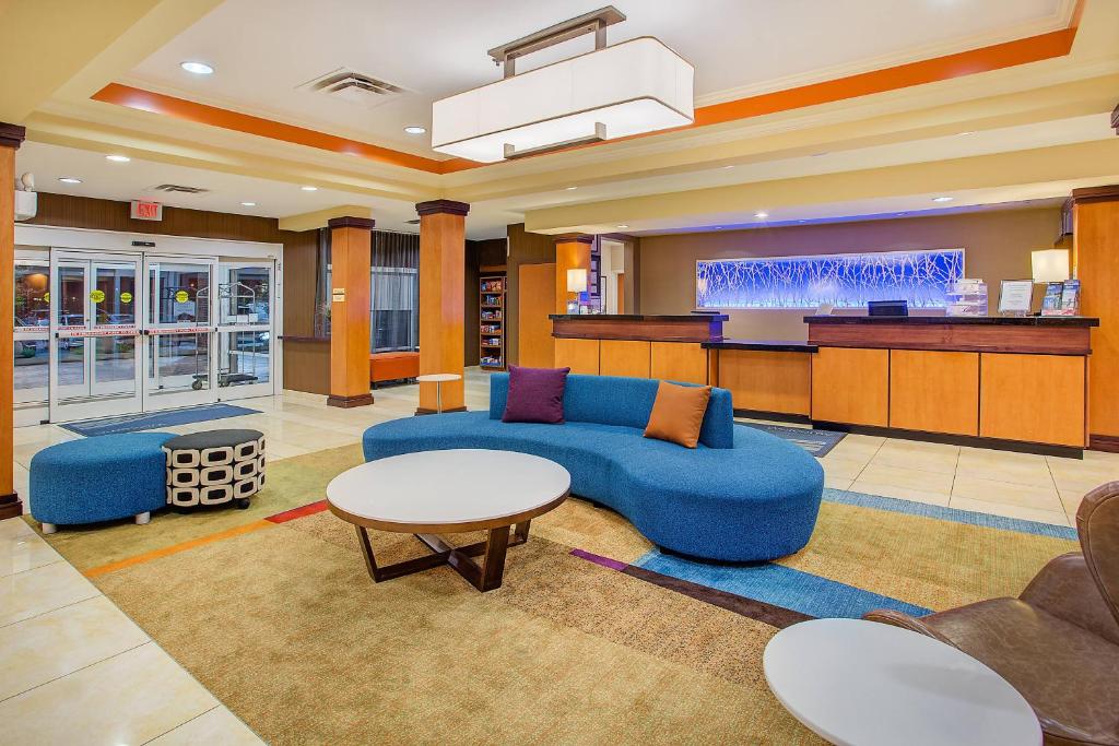 a hotel lobby with a blue couch and a bar at Fairfield Inn & Suites Cookeville in Cookeville