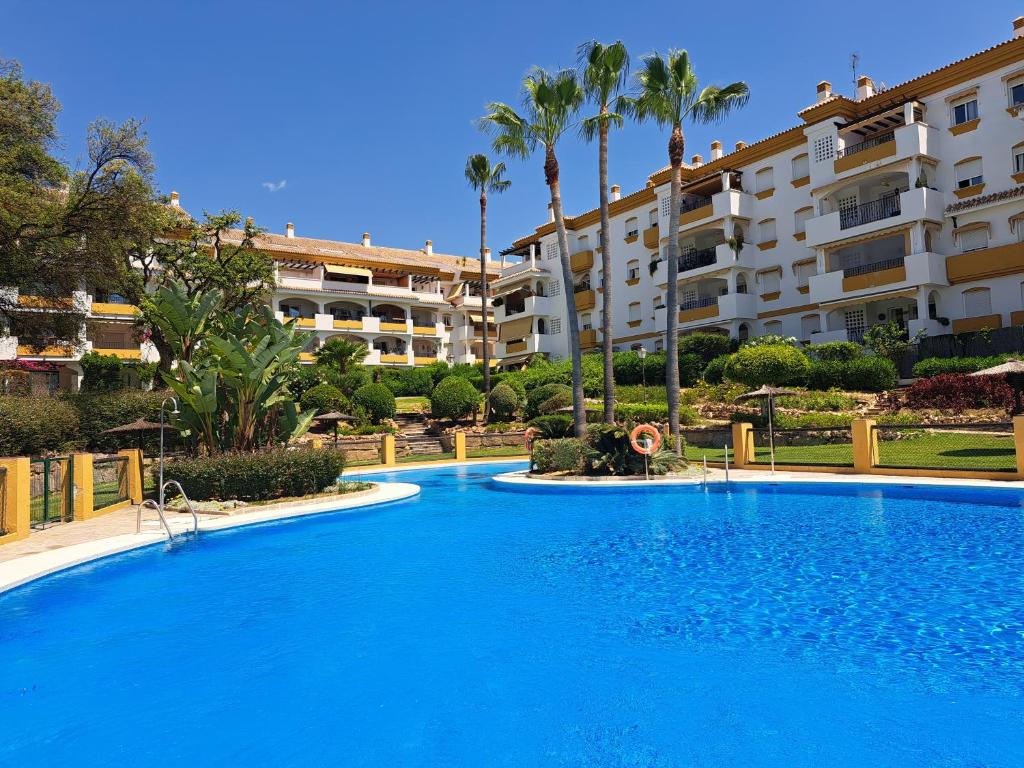 einem großen blauen Pool vor einem Gebäude in der Unterkunft La Palmera - Amazing apartment with excellent location & views in Marbella