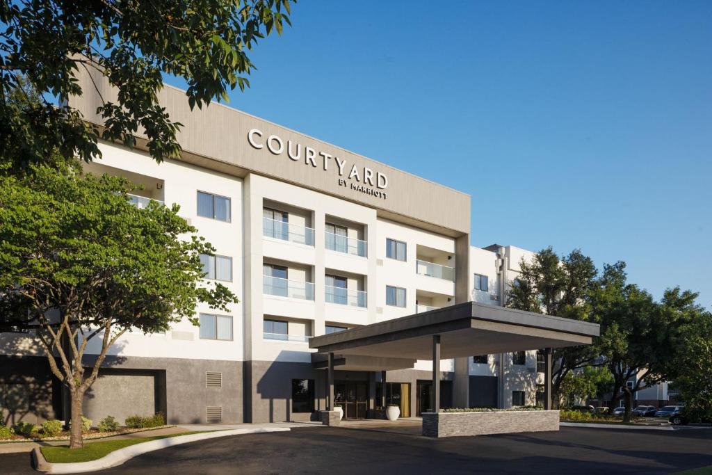 a white building with a sign on it at Courtyard Austin South in Austin