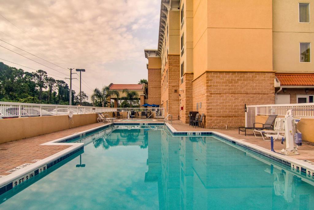een zwembad in een hotel met een gebouw bij Fairfield Inn & Suites Palm Coast I-95 in Palm Coast
