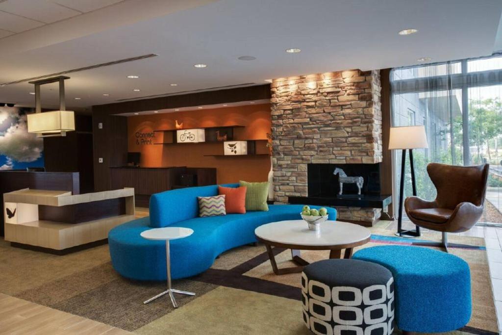 a living room with a blue couch and a fireplace at Fairfield Inn & Suites by Marriott Fort Lauderdale Pembroke Pines in Pembroke Pines
