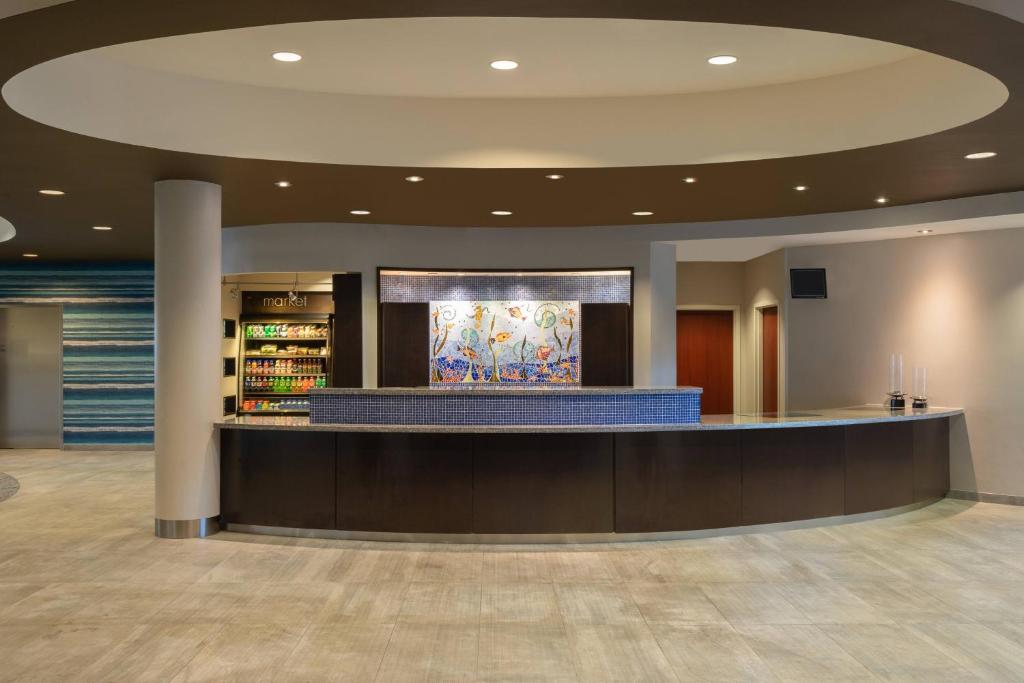 a lobby with a waiting area with a counter in it at Courtyard by Marriott Fort Lauderdale Airport & Cruise Port in Dania Beach