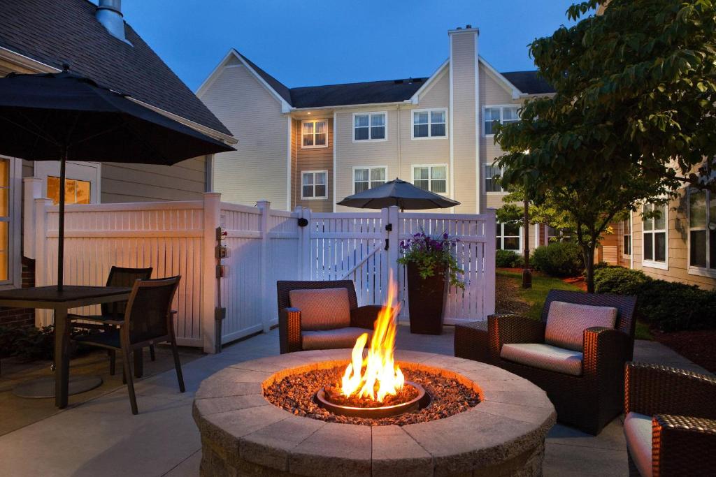 a fire pit in a patio with chairs and a table at Residence Inn Hartford Manchester in Manchester