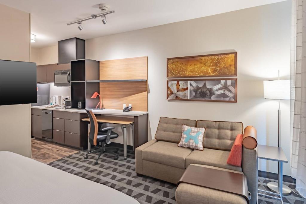 a living room with a couch and a table and a kitchen at TownePlace Suites Austin South in Austin