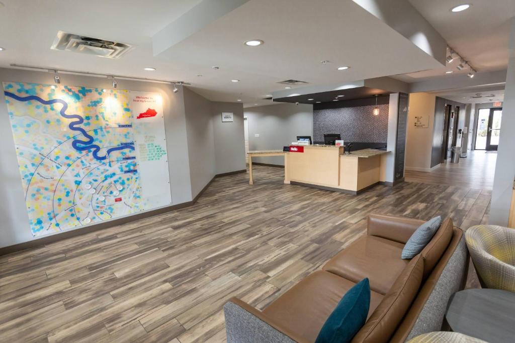 a waiting room with a couch and a large wall at TownePlace Suites by Marriott Bowling Green in Bowling Green