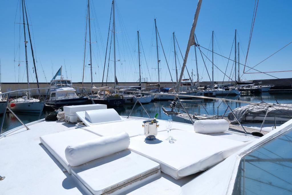 a white boat with two chairs and a table at HouseBoat Isurus Quinto in Puerto Calero