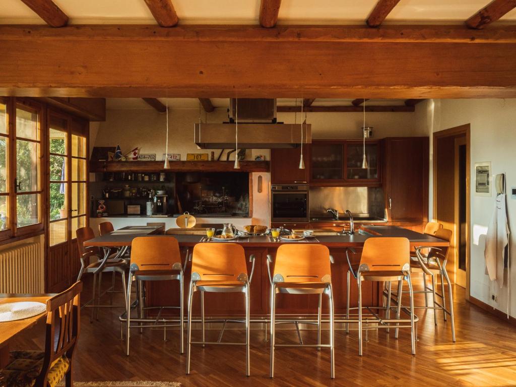 una cocina con sillas naranjas y una isla grande en B&B Casa Decimo, en Greve in Chianti