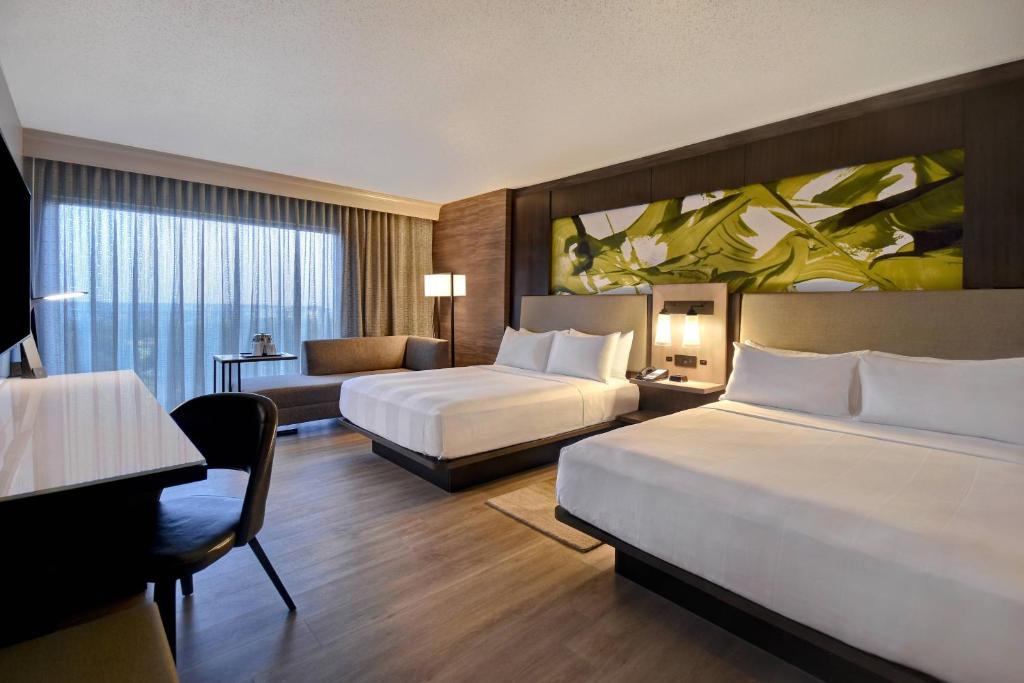 Habitación de hotel con 2 camas y sala de estar. en Dallas/Fort Worth Marriott Hotel & Golf Club at Champions Circle, en Roanoke