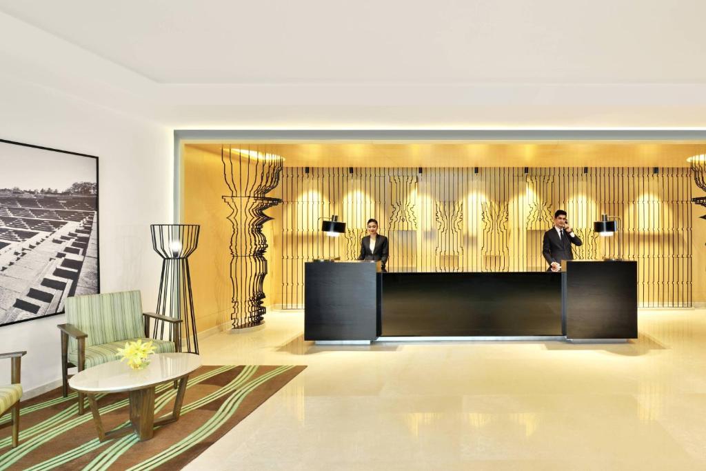 a lobby with two men standing behind a podium at Fairfield by Marriott Bengaluru Whitefield in Bangalore