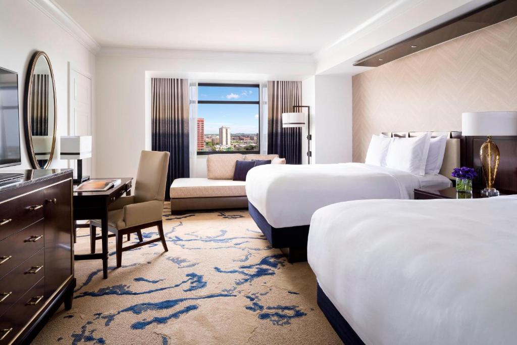 a hotel room with two beds and a desk at The Ritz-Carlton, Denver in Denver