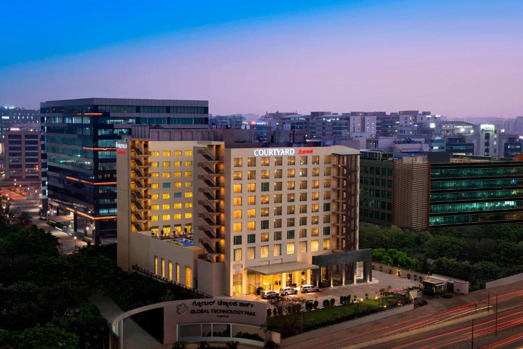 a lit up building in a city at night at Courtyard by Marriott Bengaluru Outer Ring Road in Bangalore