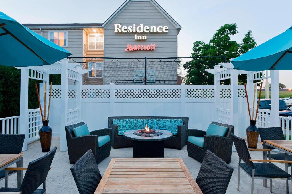 Residence Inn by Marriott Cedar Rapids في سيدار رابيدز: فناء به طاولات وكراسي به موقد
