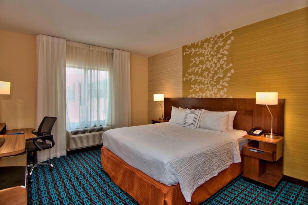 a hotel room with a bed and a desk and a window at Fairfield Inn & Suites by Marriott Towanda Wysox in Towanda
