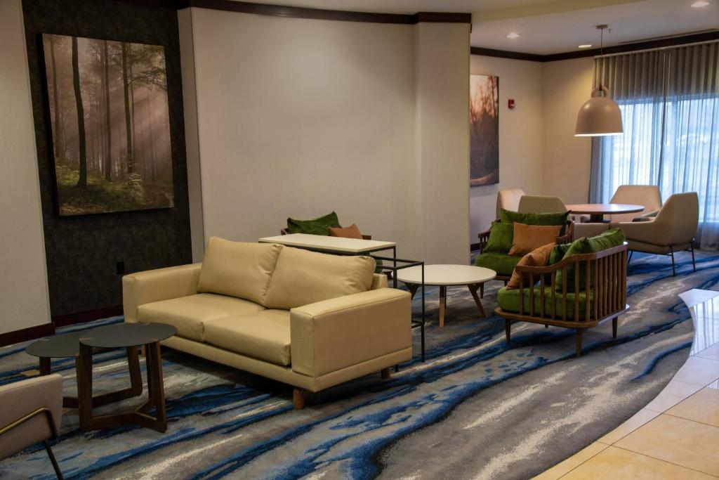 a living room with a couch and chairs and tables at Fairfield Inn & Suites Lewisburg in Lewisburg