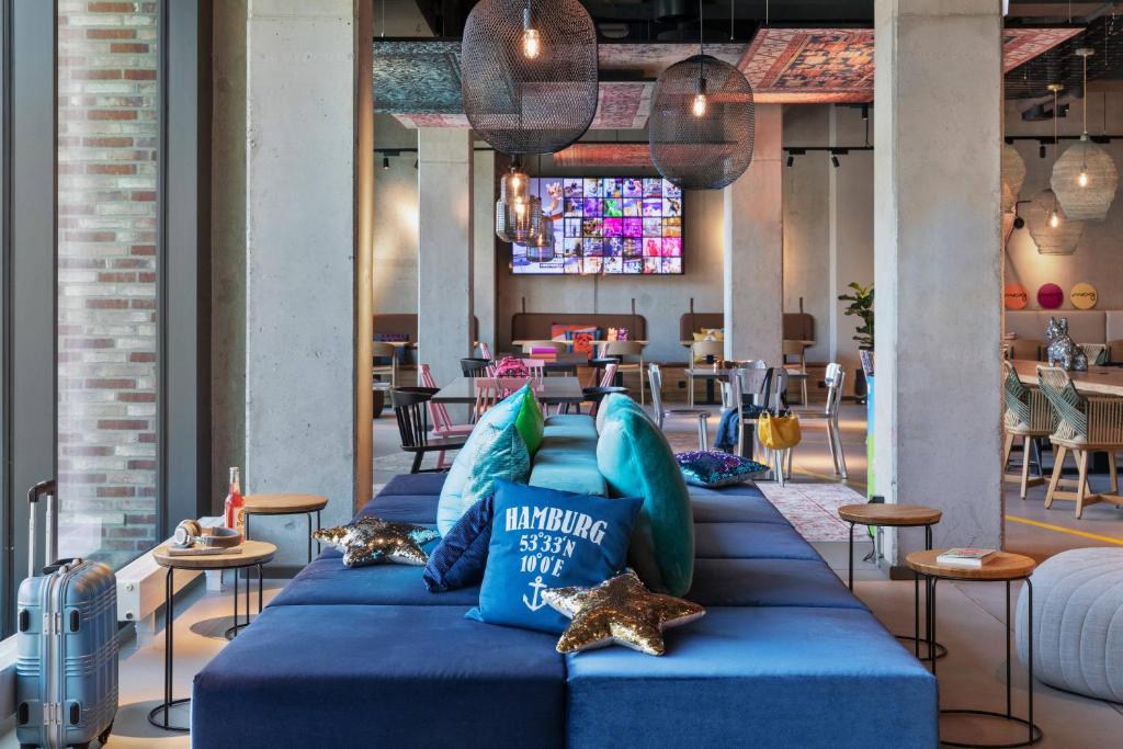 a group of blue pillows on a couch in a restaurant at Moxy Hamburg City in Hamburg