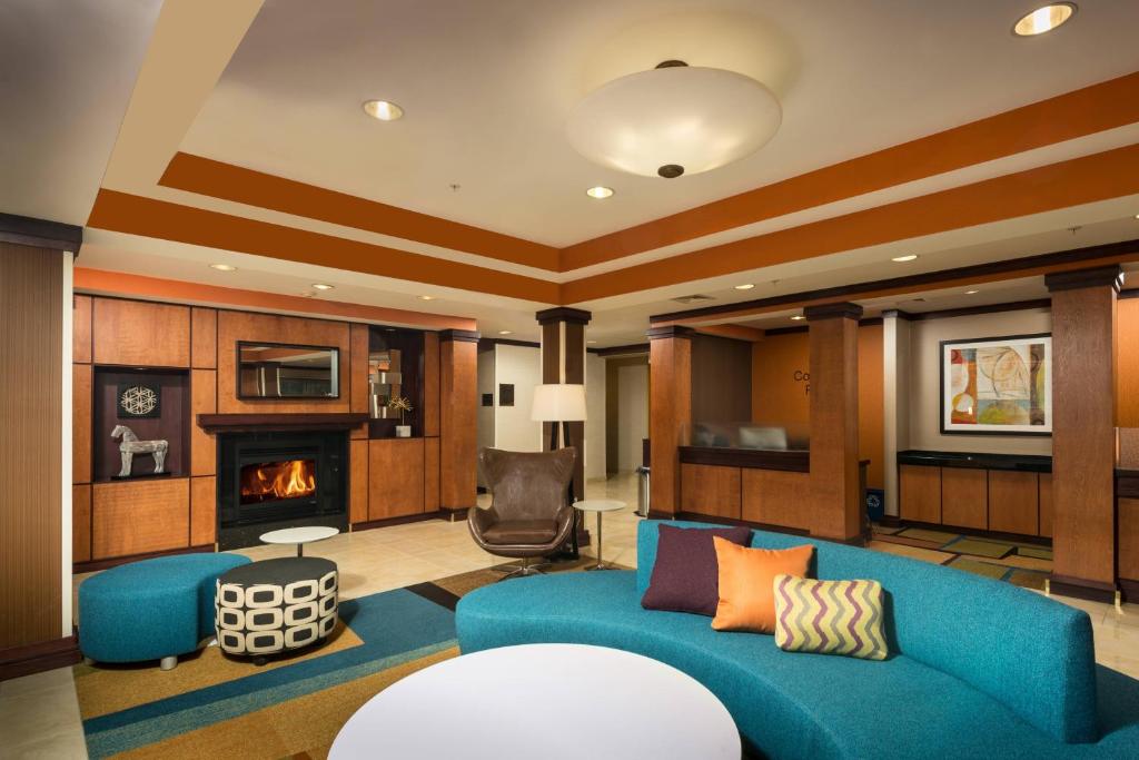 a living room with a blue couch and a fireplace at Fairfield Inn and Suites by Marriott Augusta in Augusta