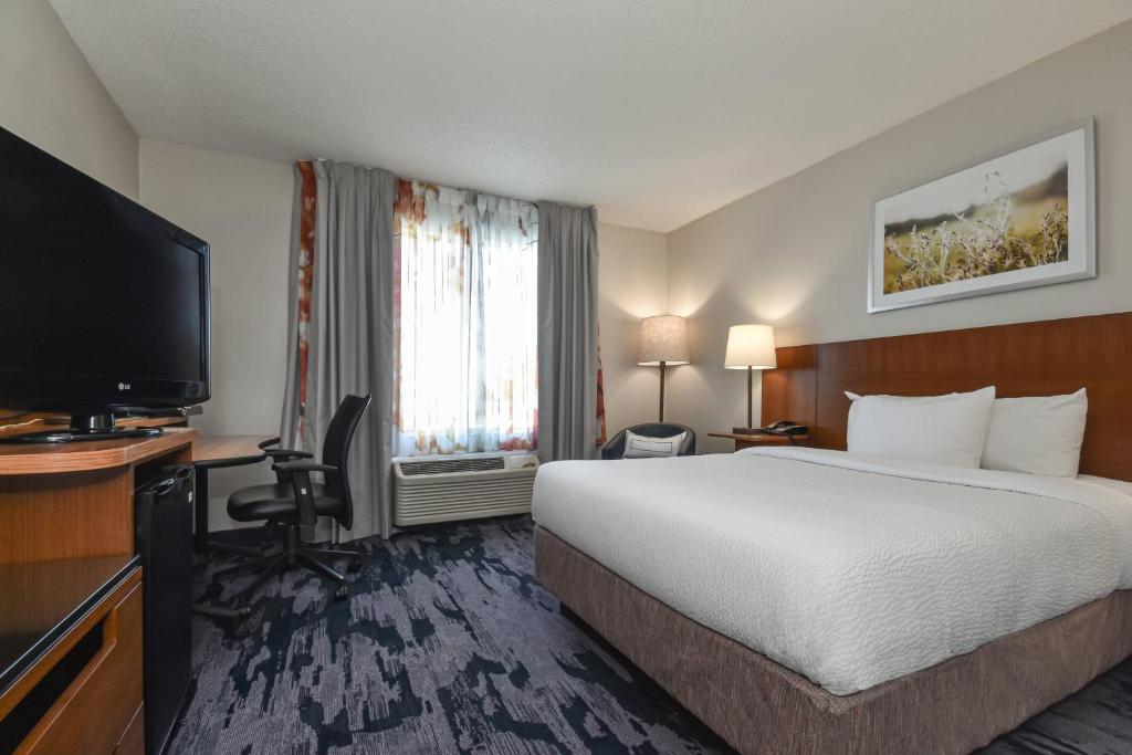 a hotel room with a bed and a flat screen tv at Fairfield Inn by Marriott Columbia Northwest / Harbison in Columbia