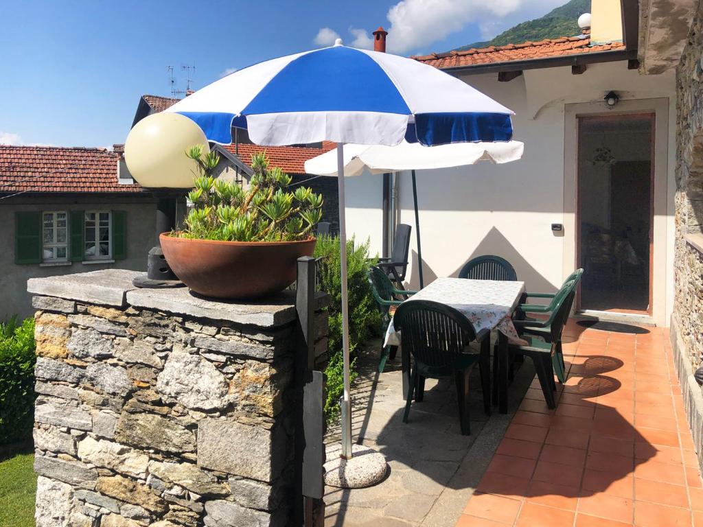 a patio with a table and an umbrella at Appartamento Porto 2 in Cannero Riviera