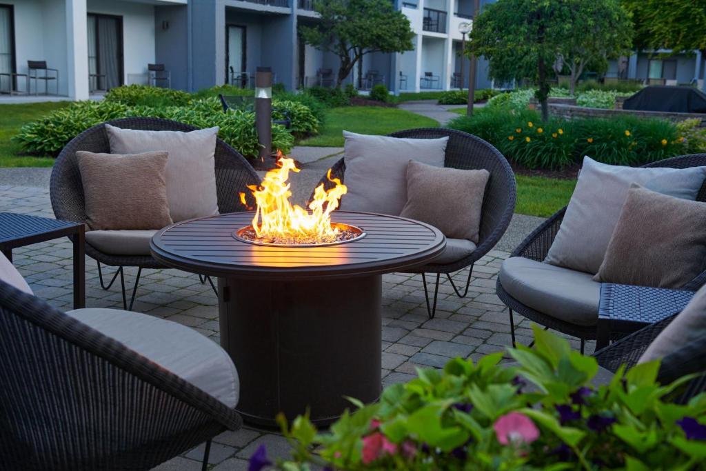 een vuurplaats op een patio met stoelen en een tafel bij Courtyard by Marriott Detroit Troy in Troy