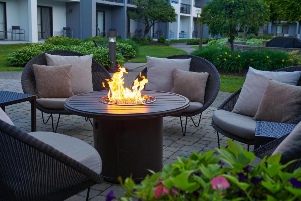 a fire pit on a patio with chairs and a table at Courtyard by Marriott Detroit Troy in Troy