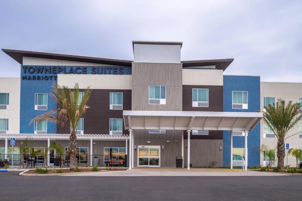 a building with palm trees in front of it at TownePlace Suites by Marriott Merced in Merced
