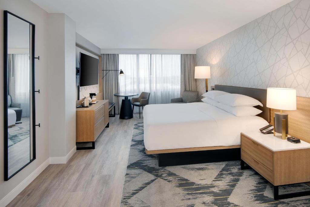 a hotel room with a large white bed and a desk at Sheraton Birmingham in Birmingham