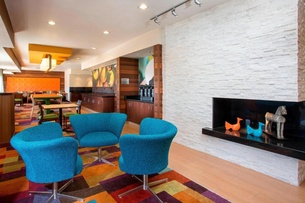 a lobby with blue chairs and a fireplace at Fairfield Inn & Suites Cheyenne in Cheyenne