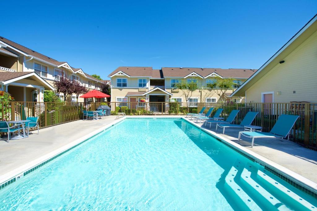 una piscina con sedie blu e condomini di TownePlace Suites by Marriott Seattle Southcenter a Kent