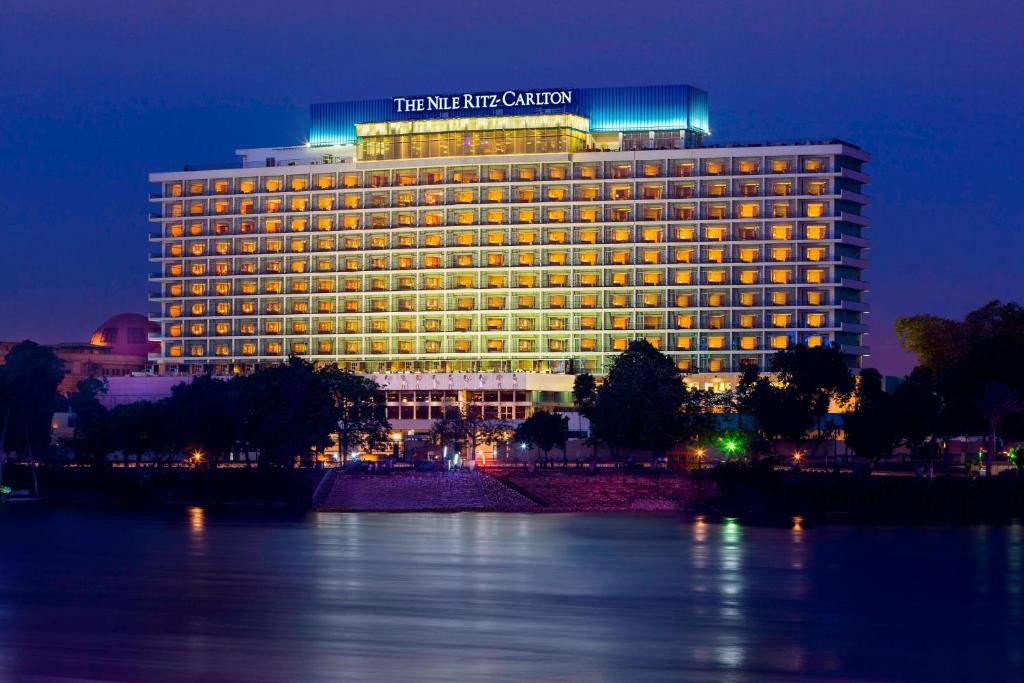 un edificio con un cartel encima por la noche en The Nile Ritz-Carlton, Cairo, en El Cairo