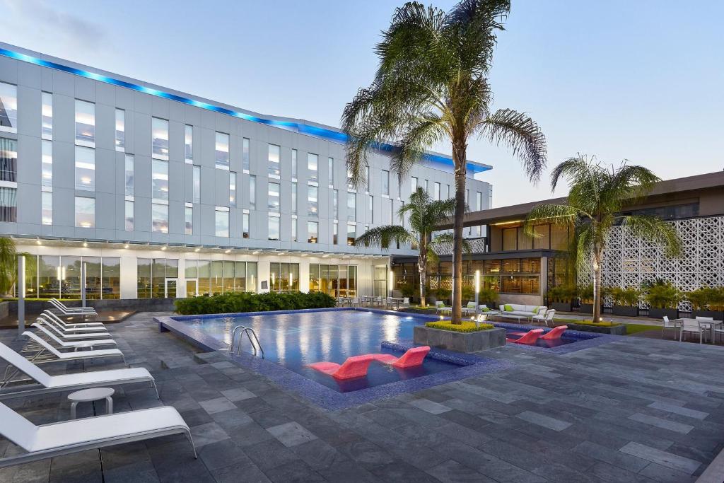 an exterior view of a hotel with a swimming pool at Aloft Queretaro in Querétaro