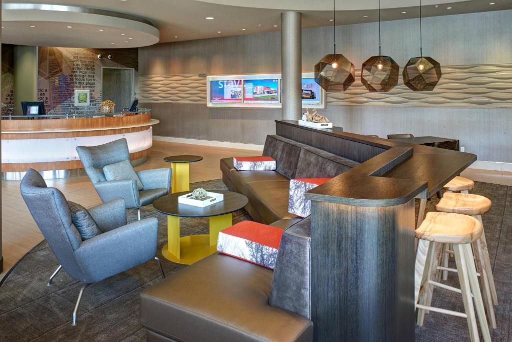 un restaurant avec des canapés et des chaises ainsi qu'un bar dans l'établissement SpringHill Suites by Marriott Saginaw, à Saginaw